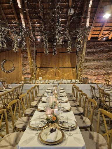 Festlich gedeckte Tafel in rustikalem Raum mit Holzdecke und dekorativen Elementen.