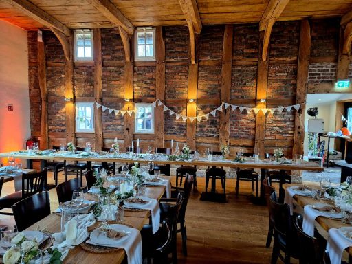 Rustikale Veranstaltungsorte mit gedeckten Tischen und dekorativer Beleuchtung.