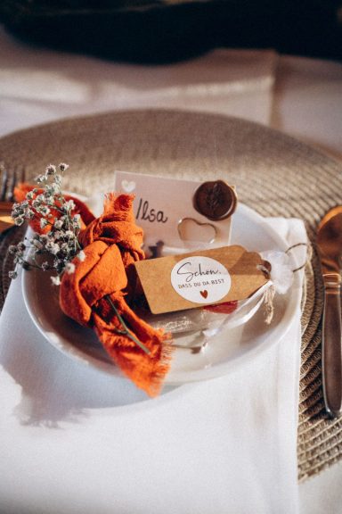 Ein dekorierter Teller mit einer Geschenkkarte und einem kleinen Strauß.